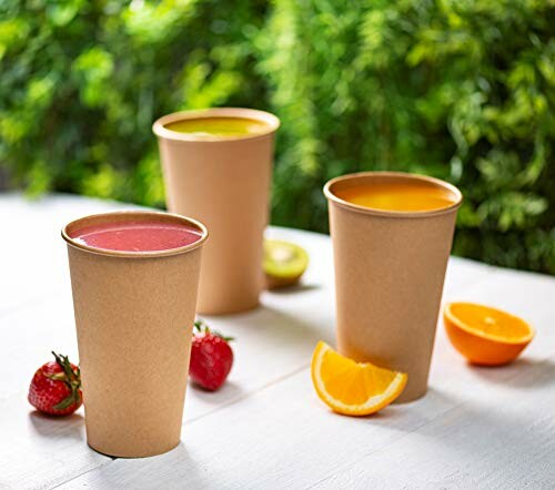 Drie bekers met kleurrijke fruitdranken op een tafel.